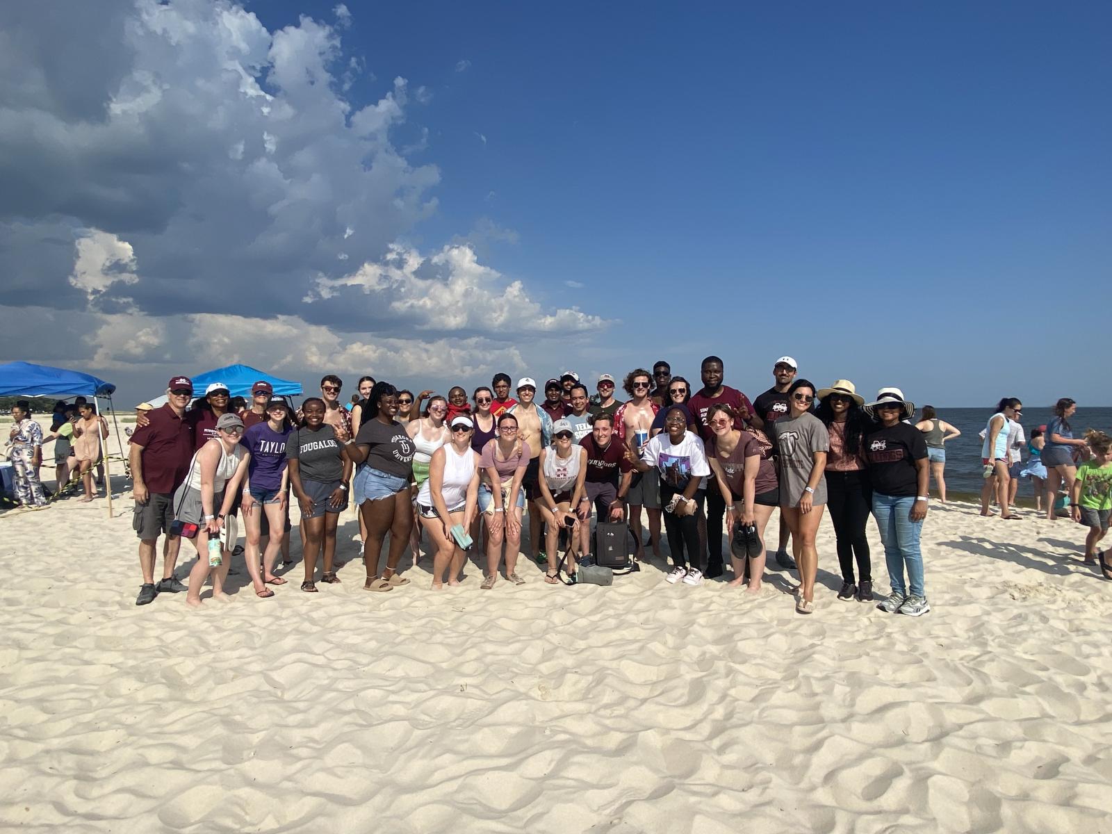 A group of participates standing on the beach at the sea turtle release in June